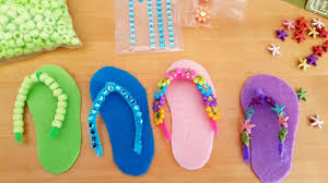 Green, blue, pink, and purple felt flip flop ornaments lined up next to each other